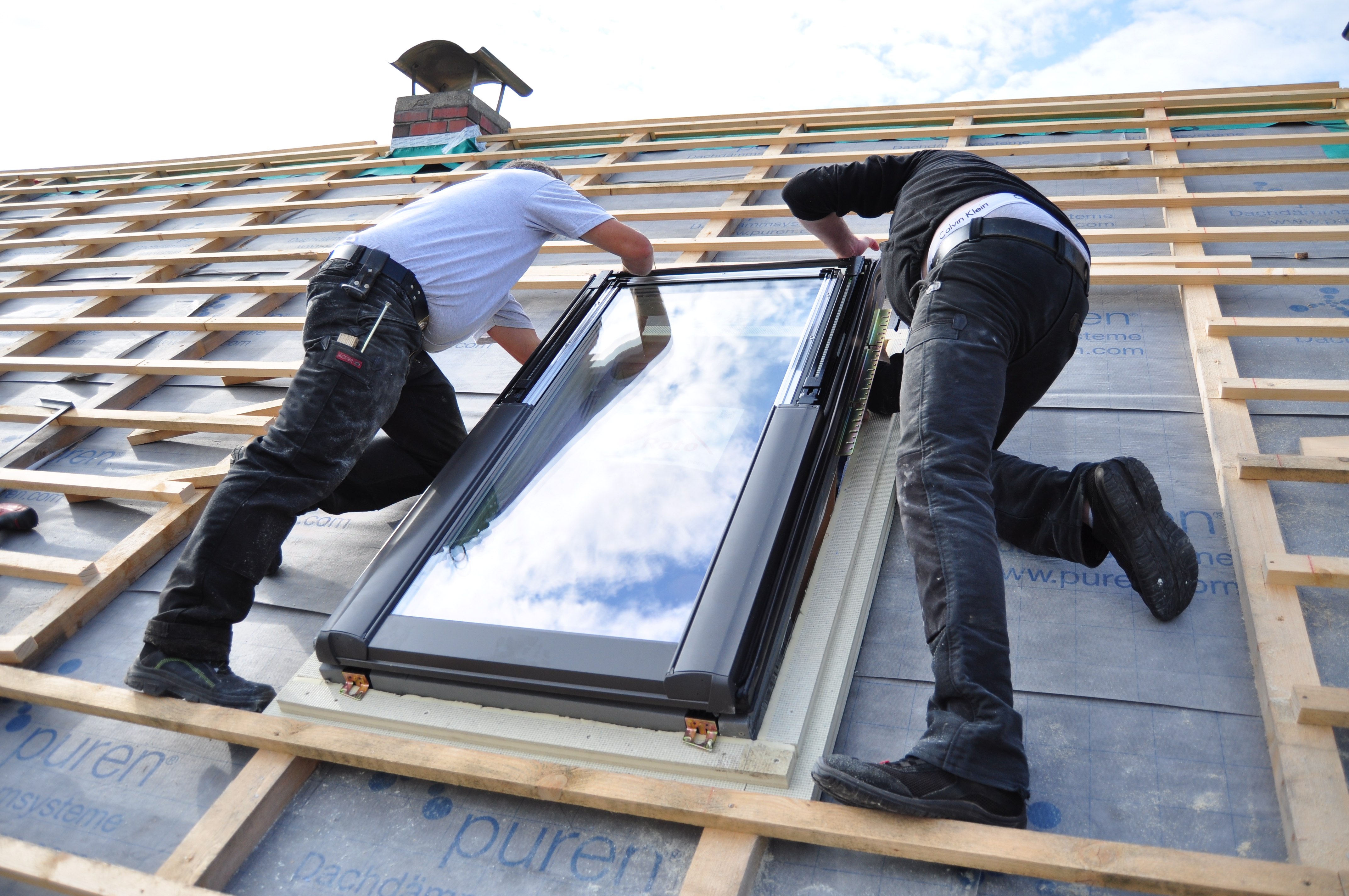 Two Men Assembling A Roof Skylight Window